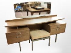 A 20th century G Plan teak dressing table fitted four drawers and a matching stool,
