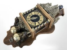 A contemporary continental brass mounted wall clock with pear drop weights.