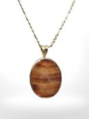 A 14ct yellow gold necklace, length 61 cm, with carved agate pendant mounted in yellow metal.