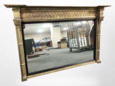 A Regency style gilt and ebonised overmantle mirror, 165 cm x 107 cm.