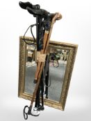 A gilt framed mirror and a bundle of walking sticks.