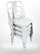 A set of four stackable enameled metal chairs.