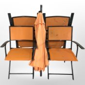Four folding garden armchairs with matching parasol in orange fabric.
