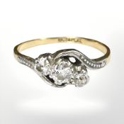 An 18ct gold gold and platinum three stone diamond crossover ring,