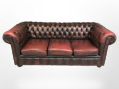 A Burgundy leather three seater Chesterfield settee, width 195 cm.