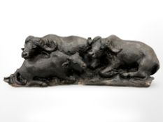A carved hardwood water buffalo figure group on wooden carved plinth,