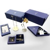 A group of Swarovski crystal, to include flower ornament, boxed stand, three crystal brooches,