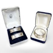 A pair of sterling silver napkin rings, together with a further silver napkin ring in case.