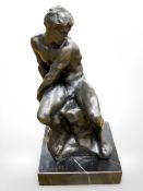 A contemporary bronze figure of a man seated on a rock, standing on square black marble plinth,