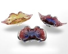 Three continental coloured glass bowls, largest width 31 cm.