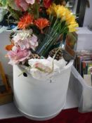 A glass terrerium and a quantity of faux flowers.
