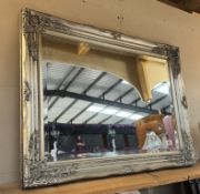 An ornate silver coloured bevel edged mirror (64 x 84cm) COLLECT ONLY