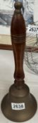 A brass hand bell with wooden handle