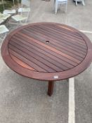 A large circular wooden garden table