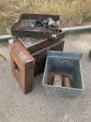 A large metal firepit with metal log bucket
