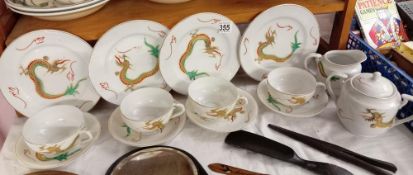 A tea set with dragon design including 4 plates, 4 cups & saucers, milk jug & sugar pot