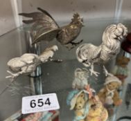 3 White metal cockerels