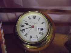 A brass ship's clock marked Fisher Collear.