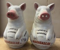 A pair of ceramic pig advertising water jugs