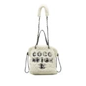 Chanel Shearling Coco Neige Tote This satchel features a shearling wool body, leather-woven chain