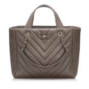Chanel CC Chevron Satchel This satchel features a quilted leather body, flat leather handles, a flat