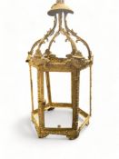 A late 19th / early 20th century gilt metal lantern frame, a coaching lamp and two storm lanterns