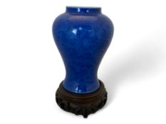 A 19th century Chinese porcelain blue self patterned monochrome baluster vase on a pieced hardwood