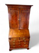 A George I burr walnut, crossbanded and featherbanded bureau cabinet
