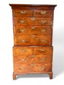 A George I walnut crossbanded and featherbanded chest on chest