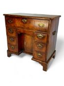 A George I walnut, crossbanded and featherbanded secretaire kneehole desk