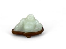 A jade seated Buddha on a hardwood stand