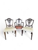 Two late 19th century mahogany carved dining chairs in the Adam taste and a similar open armchair