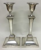 A fine pair of silver candlesticks with engraved borders. London 1909. By Stewart Dawson & Co Ltd.