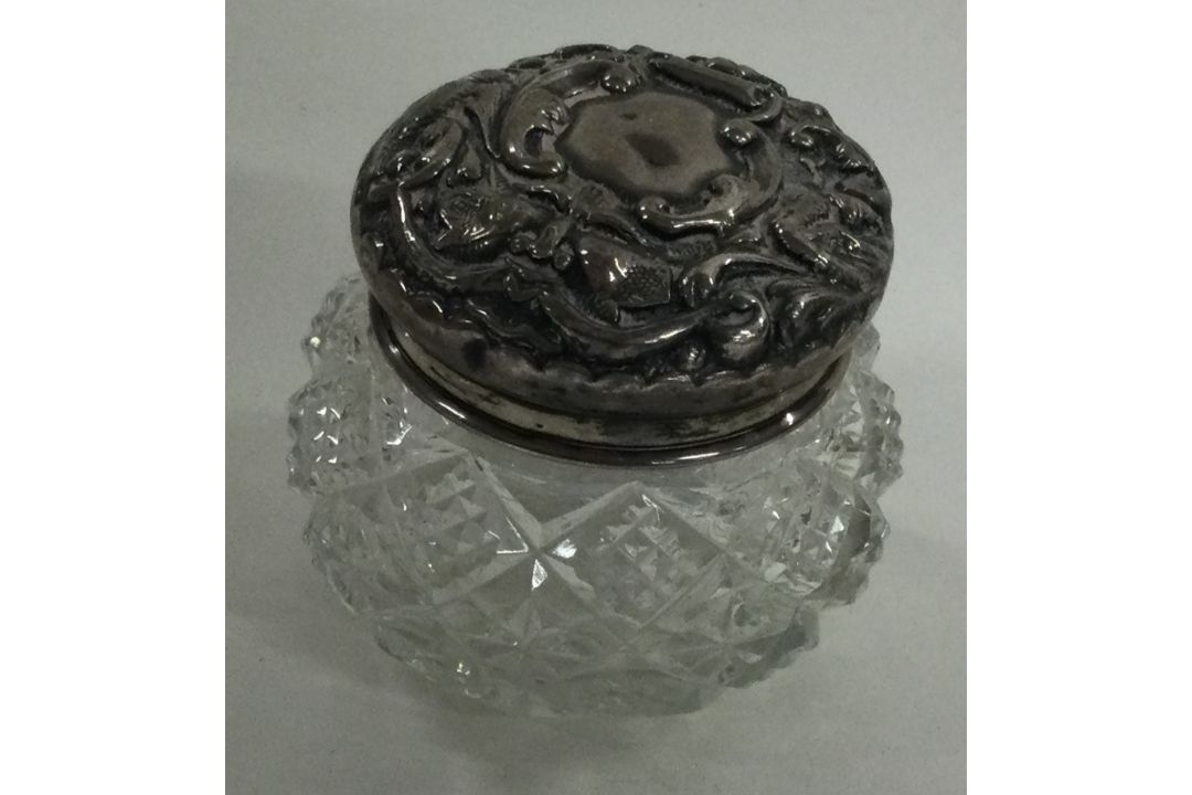 A chased silver and glass scent bottle.