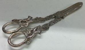 A pair of silver grape scissors embossed with foxes and foliage.
