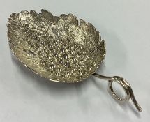 A fine quality Victorian silver caddy spoon of naturalistic form embossed with flowers.