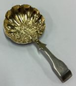 A George III chased silver caddy spoon.
