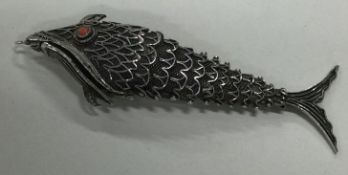An Antique silver articulated model of a fish with filigree decoration.