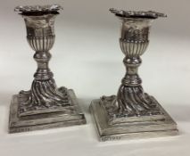A pair of Victorian silver candlesticks on square bases.