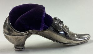 A Victorian silver pin cushion in the form of a shoe.