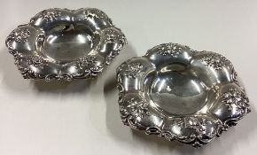 A pair of chased silver dishes embossed with flowers.