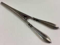 A pair of silver handled glove stretchers.