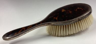 A silver mounted and tortoiseshell clothes brush.