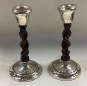 CHESTER: A pair of silver mounted and wood candlesticks.