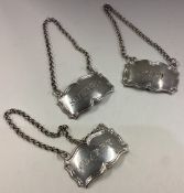 A suite of three Victorian silver wine labels.