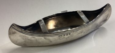 A silver model of a canoe.