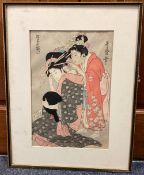 A framed and glazed woodblock print depicting Japanese ladies.