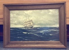 A wooden framed and glazed picture of a galleon at sea.