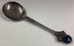 An Art Nouveau silver serving spoon with grape and vine decoration.