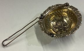 A 19th Century French silver gilt tea strainer / infuser with chased decoration.